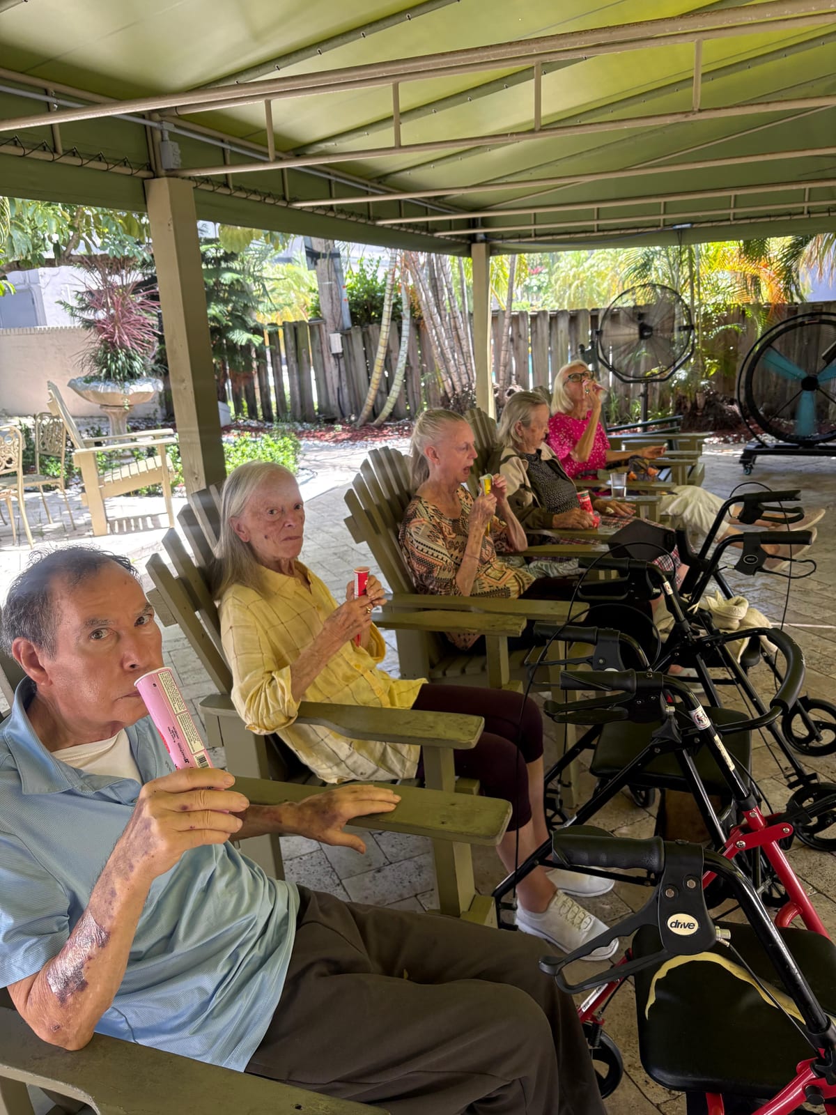 Residents sharing a simple patio afternoon at Royal Palm Senior Residence.