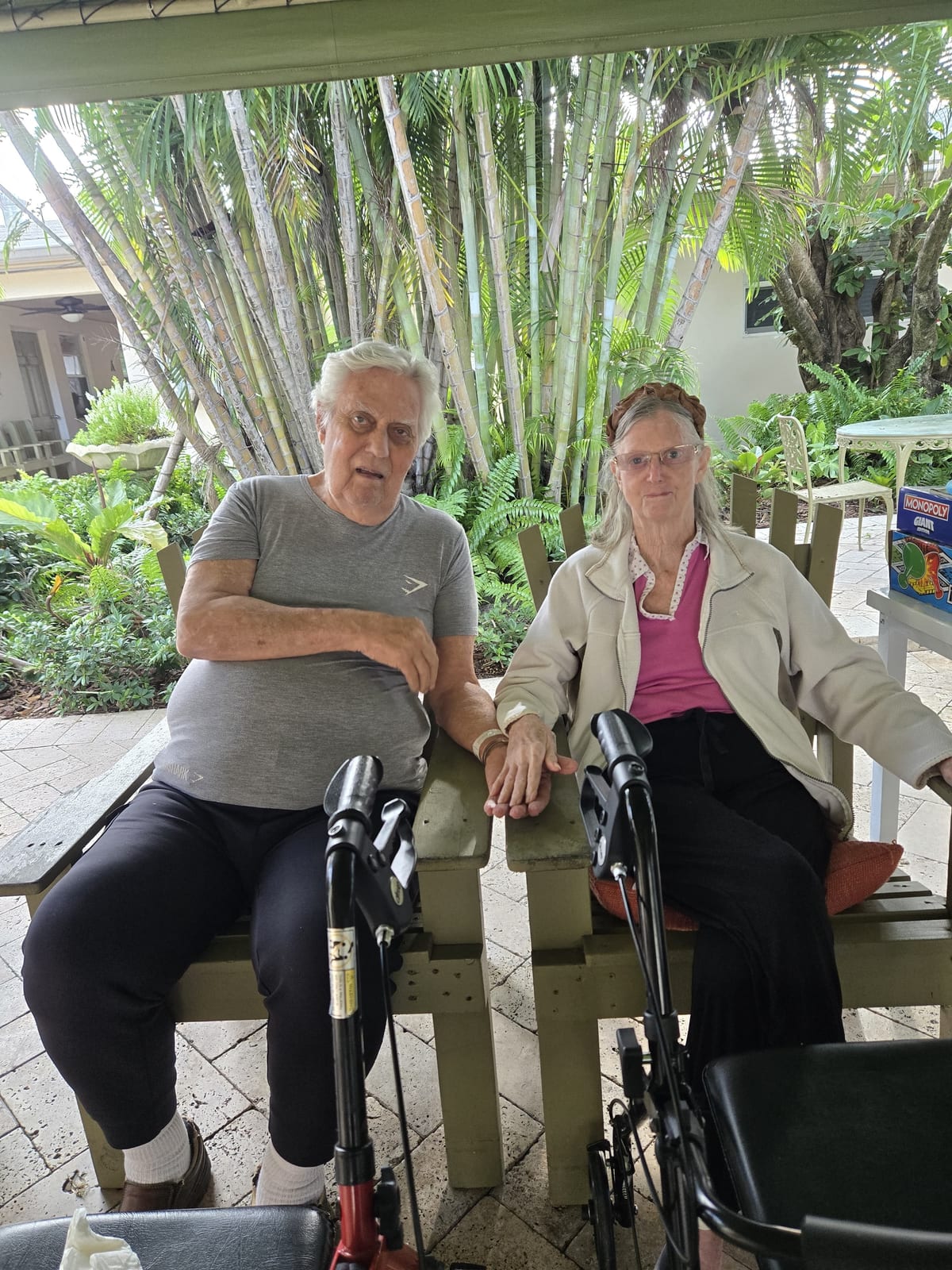 Two residents spending time together outdoors at Royal Palm Senior Residence.