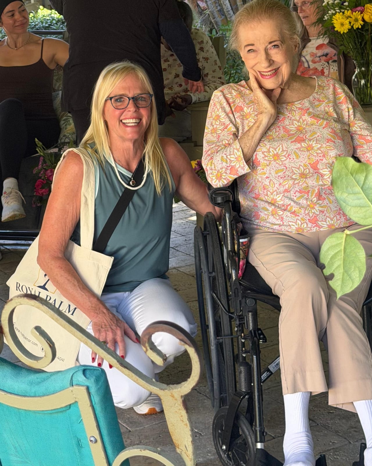 A caregiver and resident together in the garden at Royal Palm Senior Residence.
