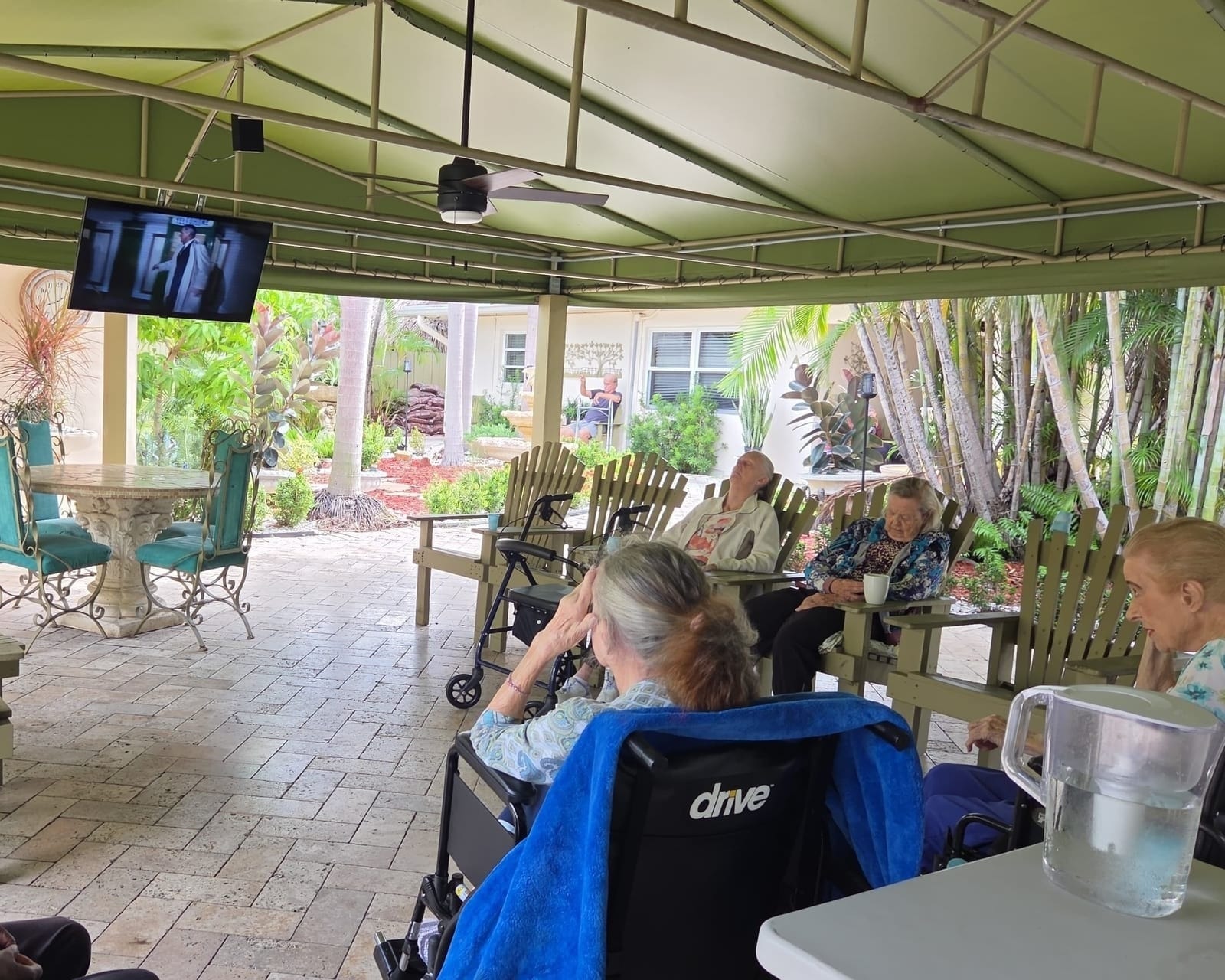 Residents talking on the covered patio at Royal Palm Senior Residence.
