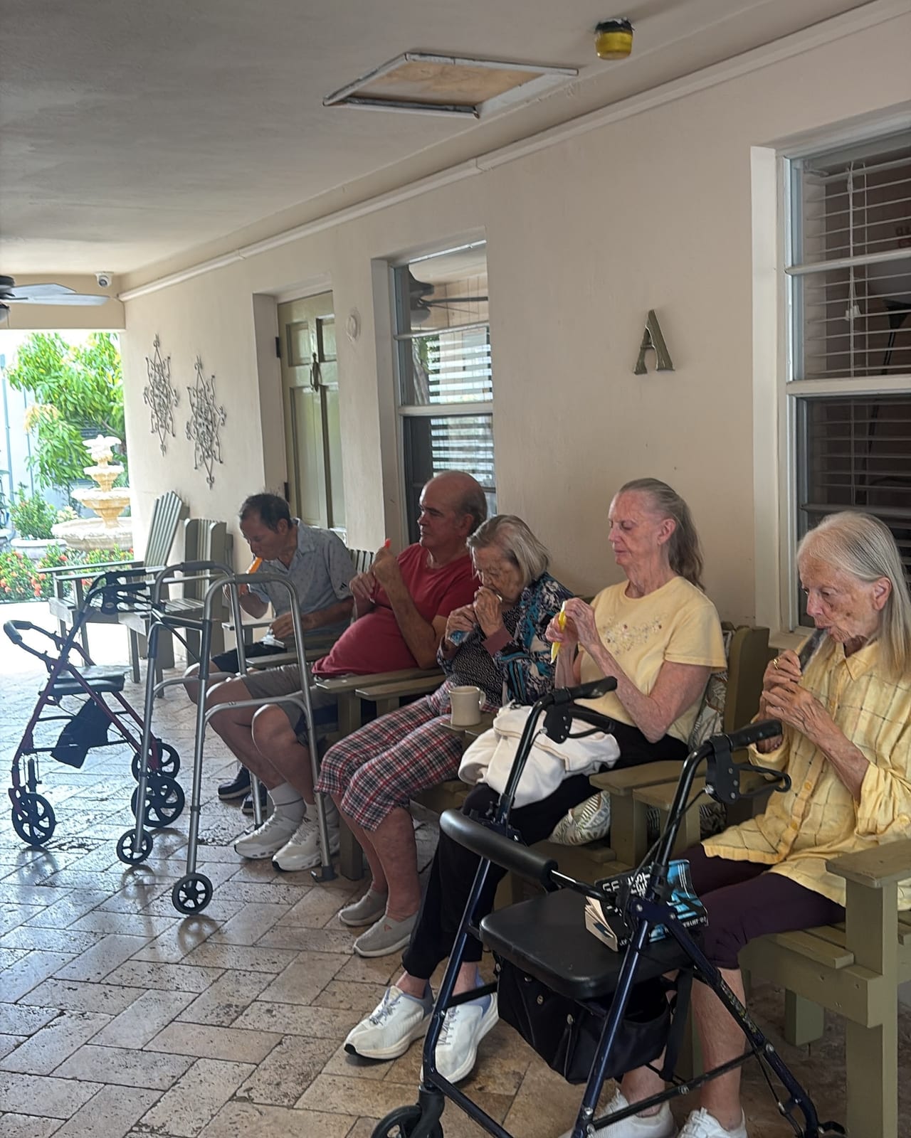 Residents sitting together on the porch at Royal Palm Senior Residence.