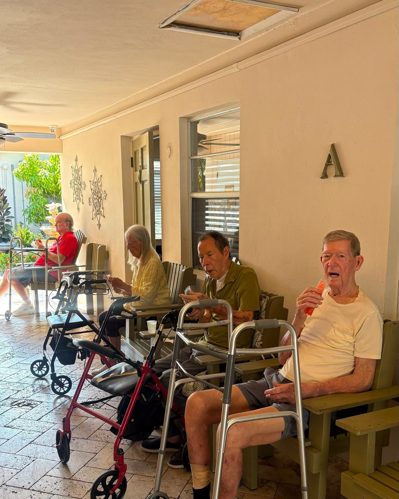Residents enjoying a sunny porch afternoon at Royal Palm Senior Residence.