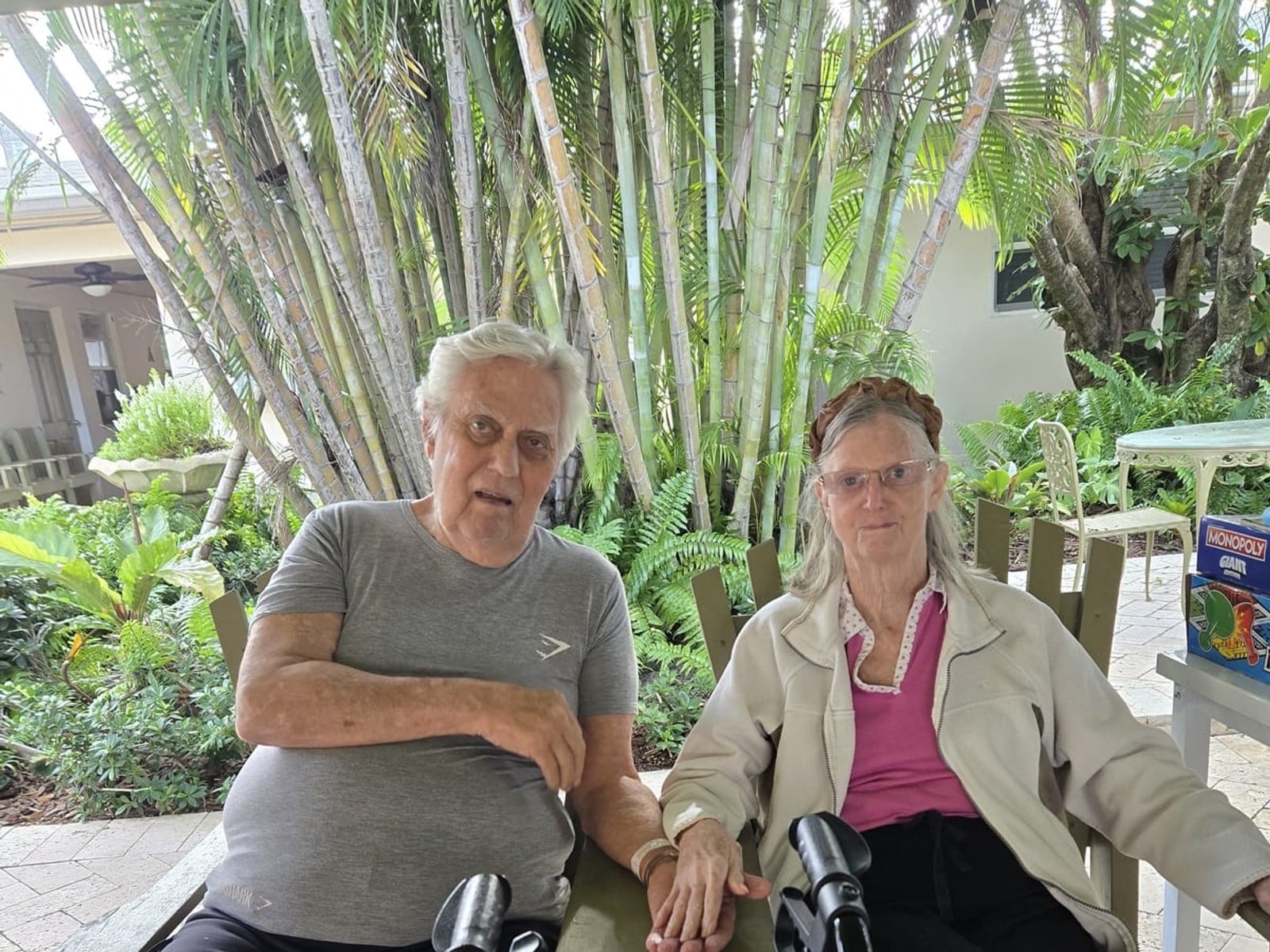 Two residents spending time together outdoors at Royal Palm Senior Residence.