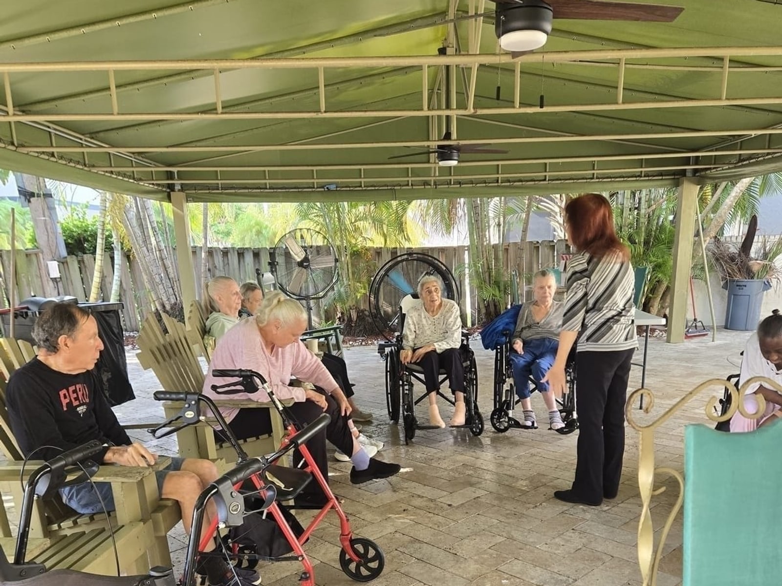 Staff spending time with residents under the patio at Royal Palm Senior Residence.
