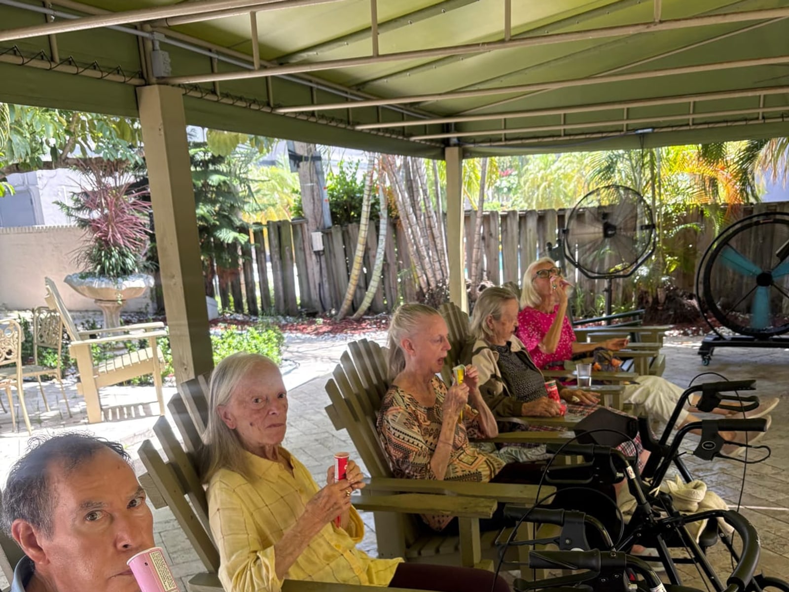 Residents sharing a simple patio afternoon at Royal Palm Senior Residence.